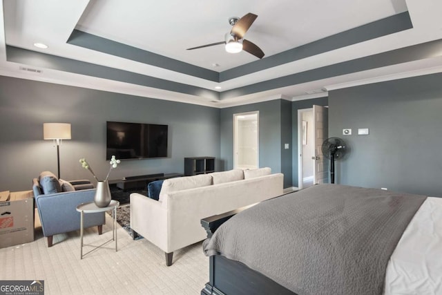 bedroom featuring ceiling fan, ornamental molding, and a tray ceiling