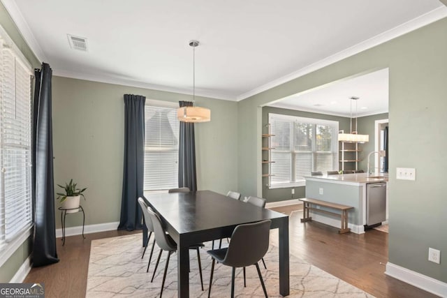 dining area featuring hardwood / wood-style floors and ornamental molding