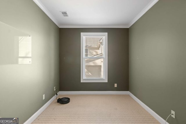 empty room featuring ornamental molding and light carpet