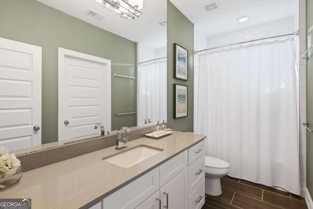 bathroom with vanity, toilet, and walk in shower