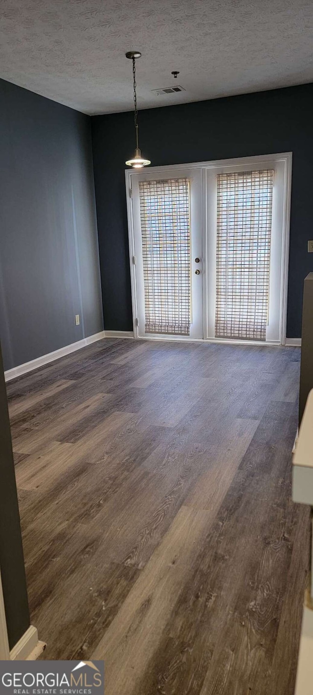 unfurnished room with wood-type flooring and a textured ceiling