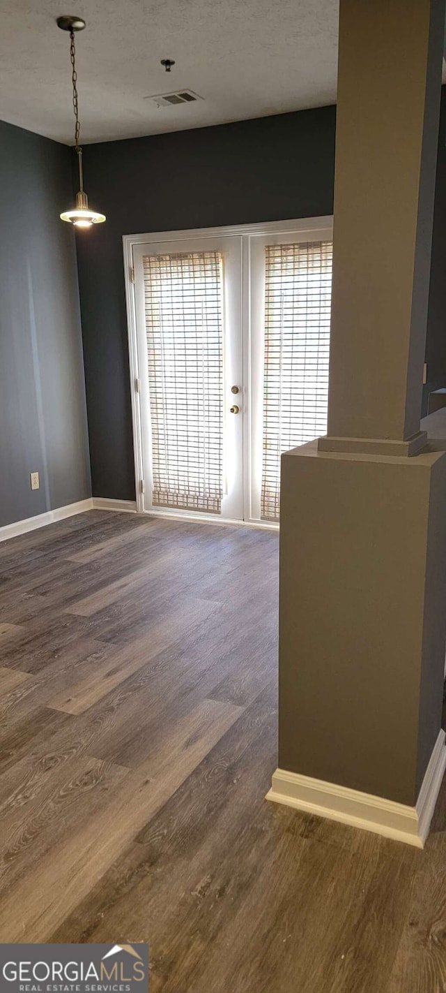 unfurnished room featuring hardwood / wood-style floors, plenty of natural light, and a textured ceiling