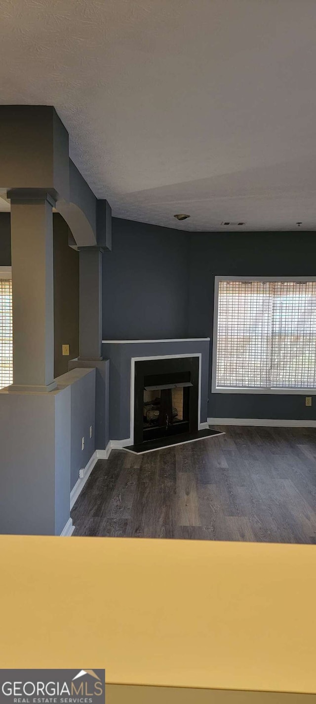 unfurnished living room with dark hardwood / wood-style flooring