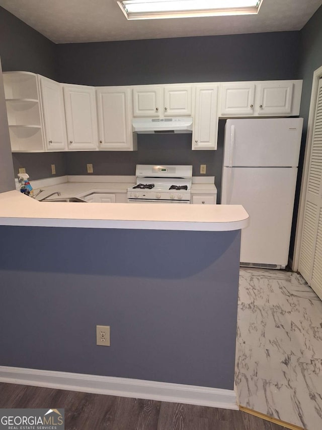 kitchen featuring sink, white appliances, kitchen peninsula, and white cabinets