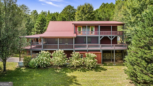 rear view of property with a sunroom and a yard