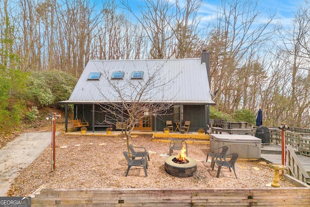 exterior space featuring a hot tub and a fire pit