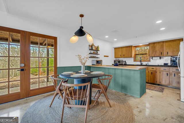 kitchen with hanging light fixtures, plenty of natural light, french doors, and white refrigerator