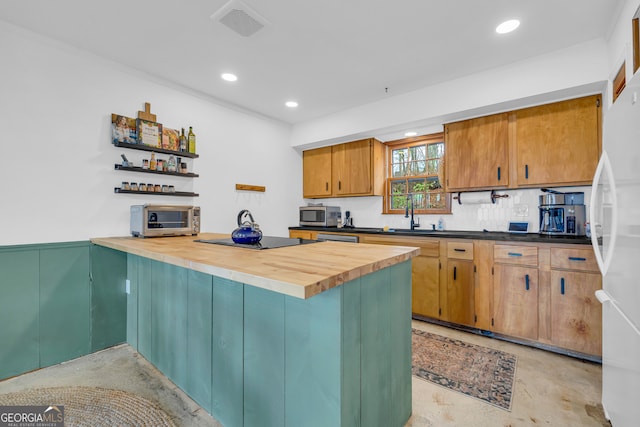 kitchen featuring tasteful backsplash, appliances with stainless steel finishes, sink, and butcher block countertops