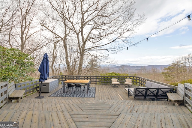 wooden terrace with an outdoor living space and a mountain view