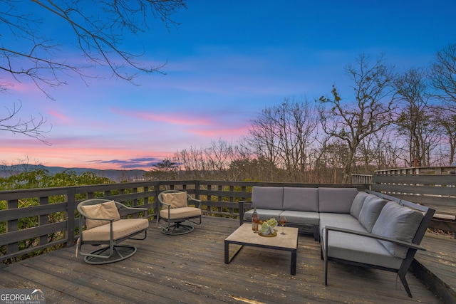 deck at dusk featuring an outdoor living space