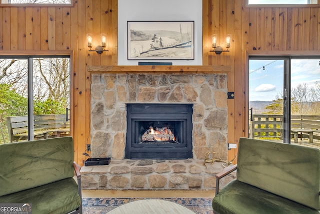 living room featuring wooden walls and a fireplace