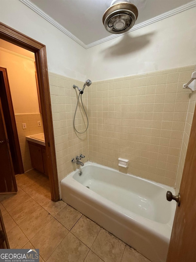 bathroom with tile walls, tiled shower / bath combo, vanity, ornamental molding, and tile patterned floors