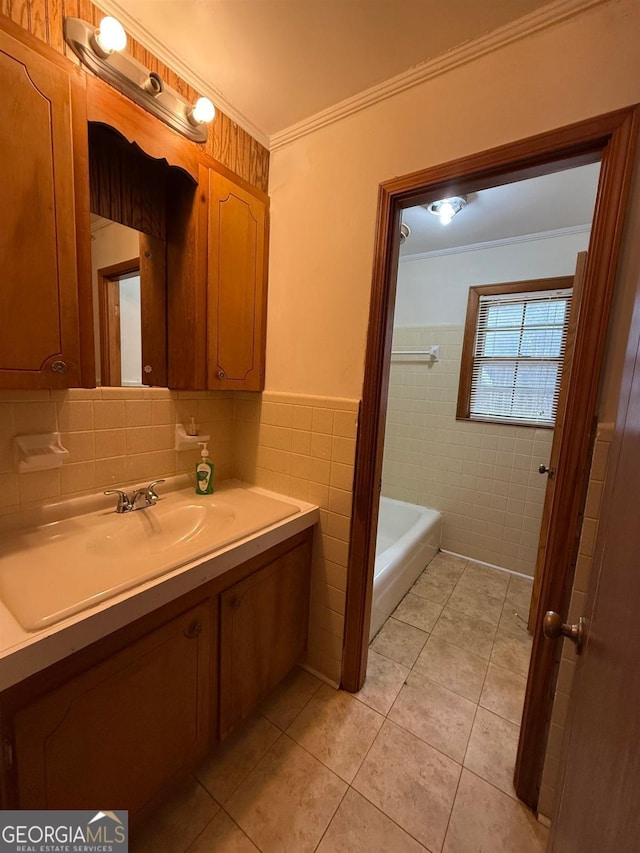 bathroom featuring crown molding, tile patterned flooring, tile walls, vanity, and a bathing tub