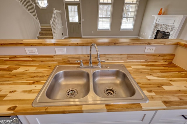 details featuring butcher block counters, sink, and a fireplace