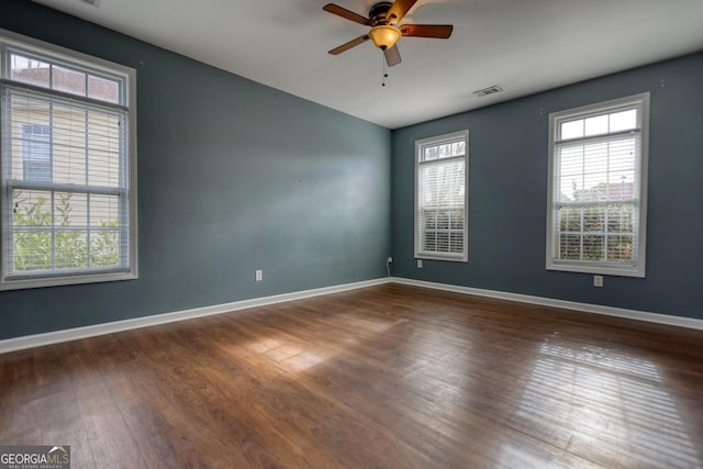 spare room with dark wood-type flooring and ceiling fan