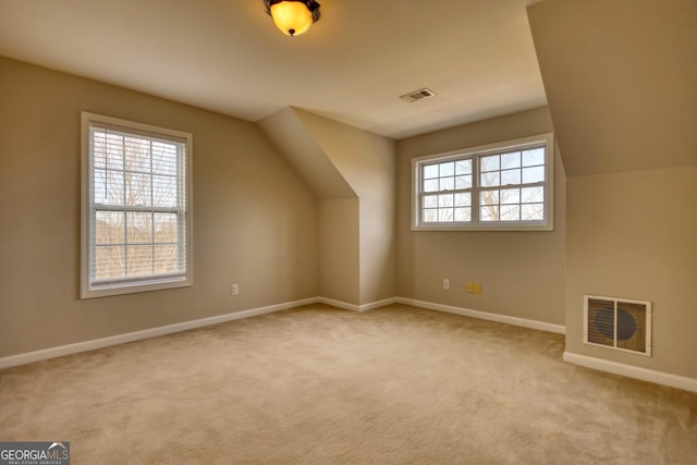 bonus room featuring light carpet and vaulted ceiling