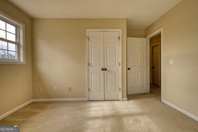 unfurnished bedroom with light carpet and a closet