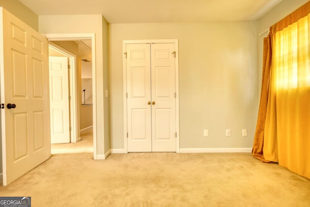 unfurnished bedroom featuring light carpet and a closet