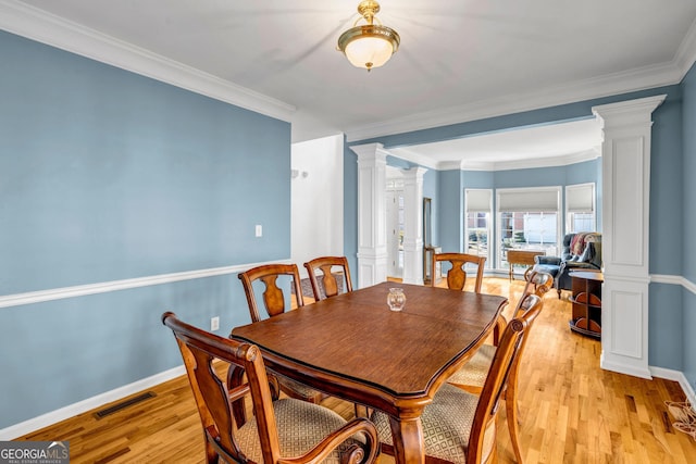 dining space with light wood-style flooring, visible vents, baseboards, ornamental molding, and decorative columns