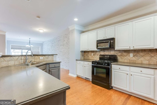 kitchen with sink, black appliances, white cabinets, decorative light fixtures, and light wood-type flooring