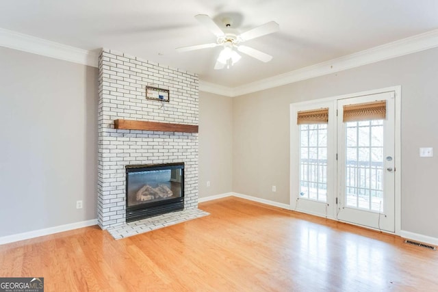 unfurnished living room with crown molding, ceiling fan, a fireplace, and light hardwood / wood-style floors