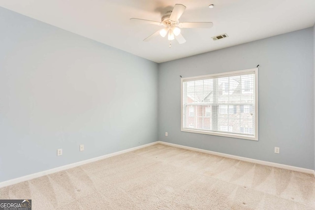 spare room with ceiling fan and light carpet