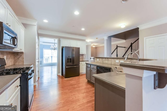 kitchen featuring white cabinetry, ornamental molding, sink, and black appliances