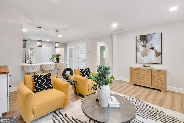 living room featuring sink and light hardwood / wood-style floors