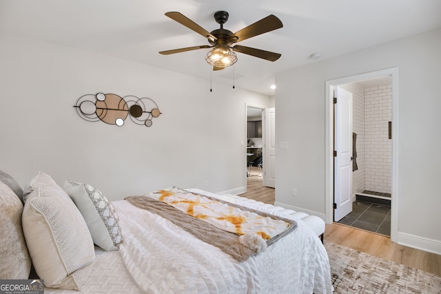 bedroom with hardwood / wood-style floors, ceiling fan, and ensuite bath