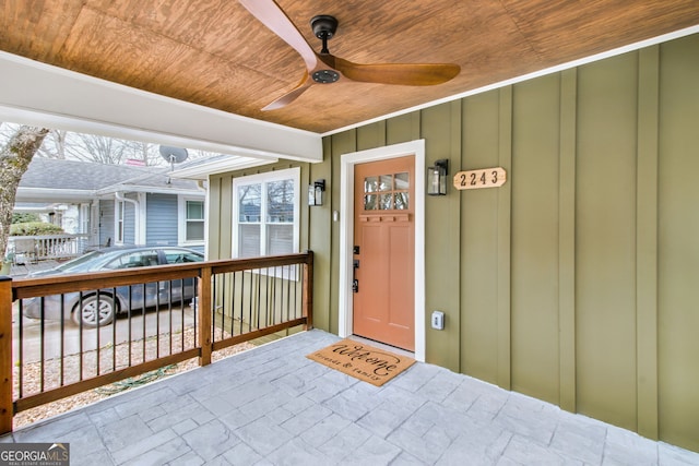 view of exterior entry with ceiling fan and covered porch