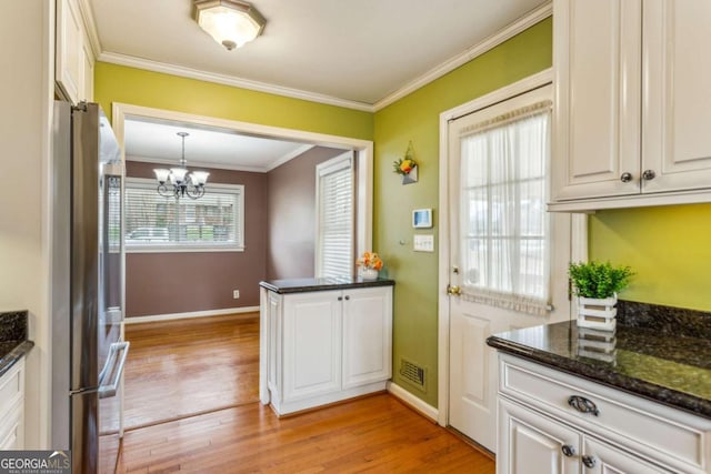 kitchen with stainless steel fridge, ornamental molding, light hardwood / wood-style floors, white cabinets, and decorative light fixtures