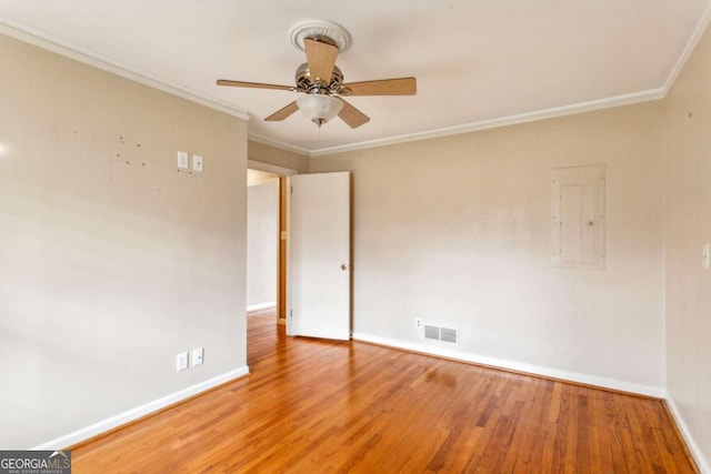 unfurnished room featuring ceiling fan, wood-type flooring, ornamental molding, and electric panel