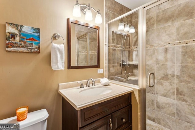 bathroom with vanity, toilet, and an enclosed shower