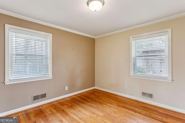 unfurnished room with hardwood / wood-style floors and crown molding