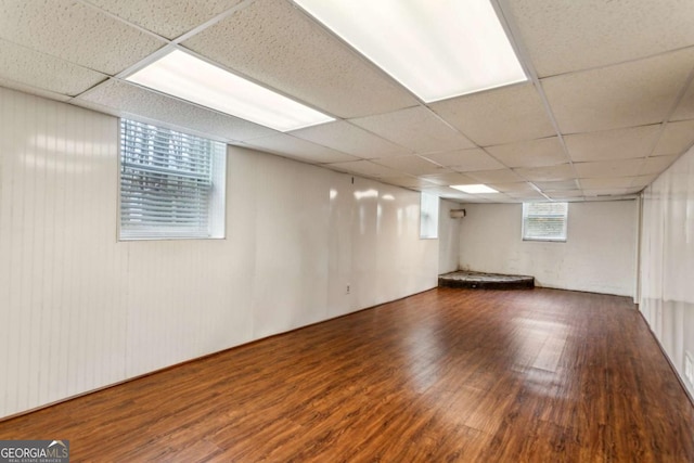 basement featuring dark hardwood / wood-style floors and a paneled ceiling