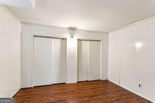 interior space featuring dark hardwood / wood-style floors and two closets