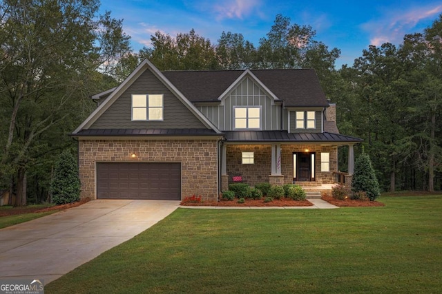 view of front of home with a garage, a yard, and covered porch