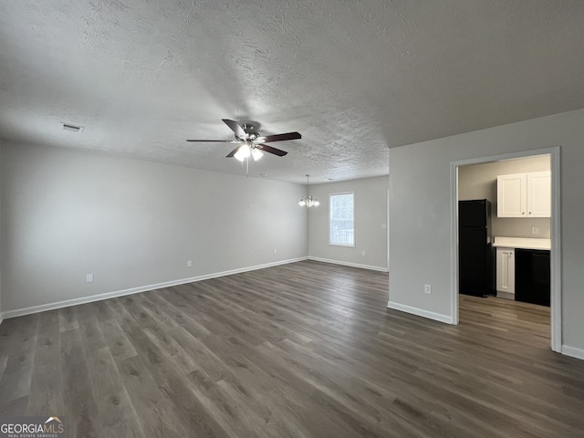 spare room featuring hardwood / wood-style flooring, ceiling fan with notable chandelier, and a textured ceiling