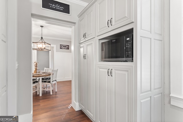 hall with ornamental molding, a chandelier, and dark hardwood / wood-style flooring