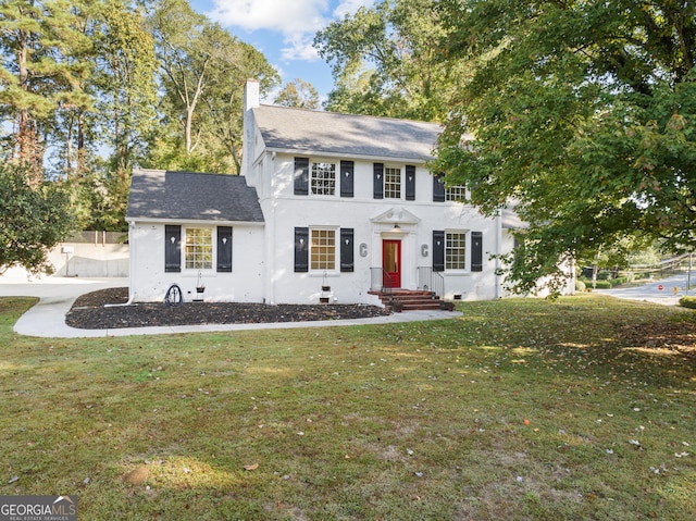 colonial inspired home featuring a front lawn