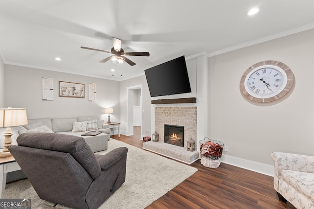 living room featuring dark hardwood / wood-style flooring, a brick fireplace, crown molding, and ceiling fan