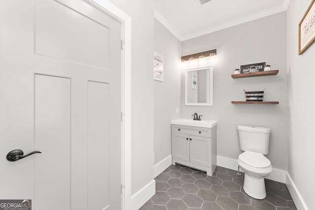 bathroom featuring crown molding, vanity, tile patterned floors, and toilet