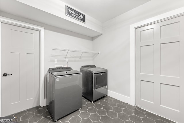 washroom with washer and clothes dryer and dark tile patterned floors