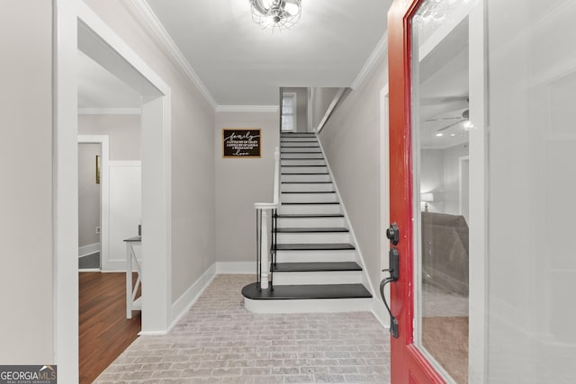 staircase with crown molding and ceiling fan