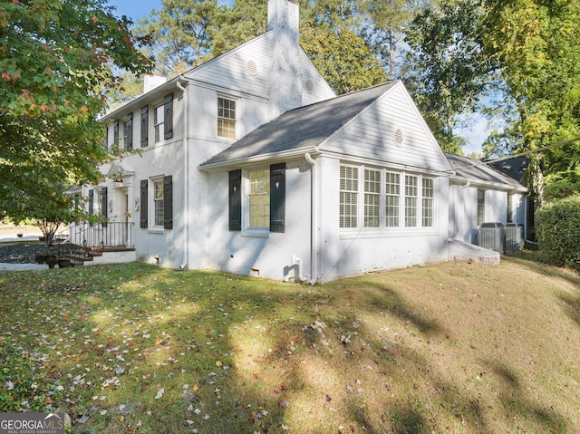 view of home's exterior featuring cooling unit and a lawn