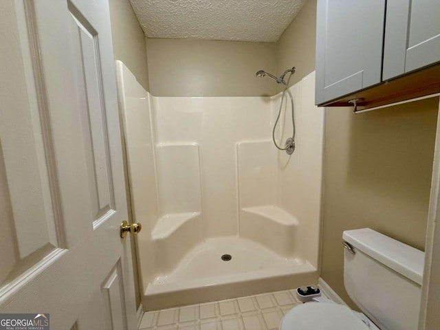 bathroom featuring toilet, a textured ceiling, and walk in shower