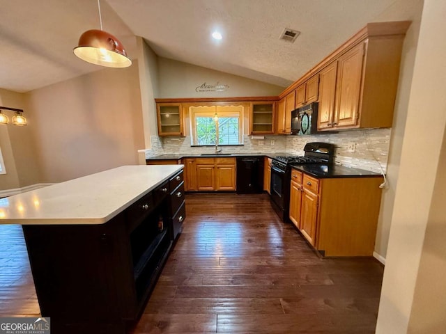 kitchen featuring lofted ceiling, sink, dark wood-type flooring, backsplash, and black appliances