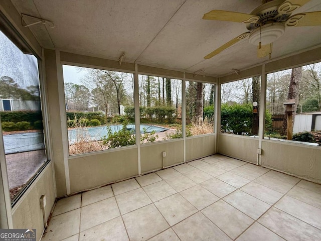 unfurnished sunroom with ceiling fan