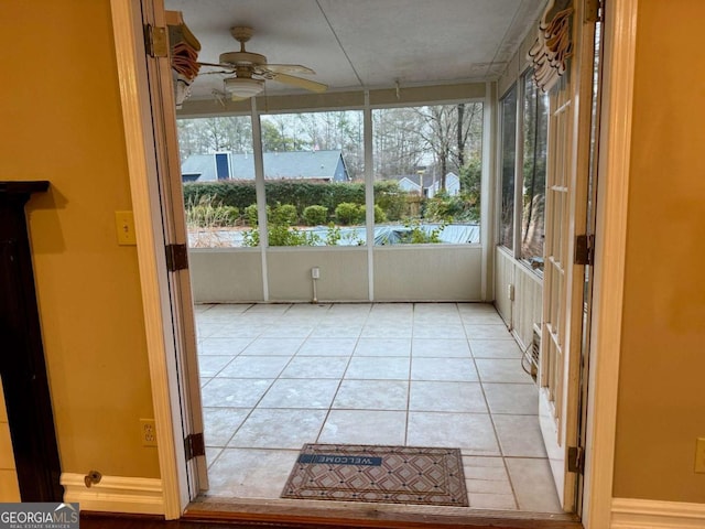 unfurnished sunroom featuring ceiling fan