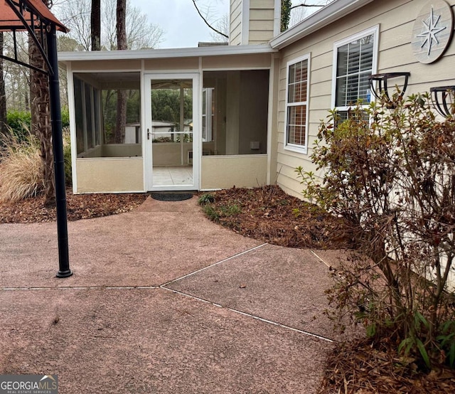 view of exterior entry featuring a patio